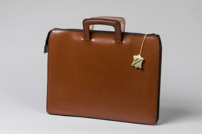 une mallette en cuir marron ornée d'une étoile dorée sur la poignée