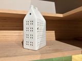 a small white house on a shelf in a room