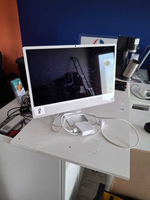 a computer monitor sitting on a desk in an office