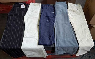 five pairs of men ' s pants sitting on a pallet