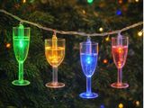 des verres à vin multicolores suspendus à une ficelle sur un sapin de Noël