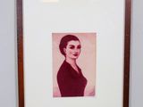 Une vieille photo d'une femme en robe noire est accrochée au mur.