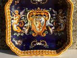 une assiette bleue et orange ornée d'un motif décoratif, posée sur une surface en pierre