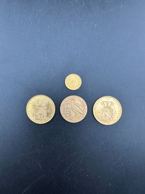 trois pièces d'or posées sur une surface noire