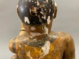 a wooden statue of a man with a hat on his head