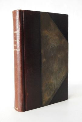 an old book with a brown cover sitting on top of a white table