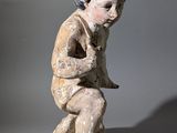 statue d'un garçon tenant un oiseau sur fond gris