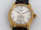 a close up of a gold wrist watch on a white surface