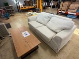 a white couch and a coffee table in a warehouse