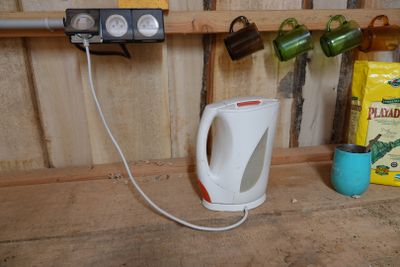 a kettle that is sitting on a shelf next to a cup