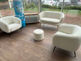 three chairs and a ottoman in the corner of a room