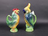 pair of colorful ceramic figurines of roosters on a black background