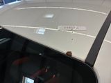 a sticker on the roof of a car that is parked in a showroom
