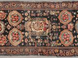 an antique persian rug with a floral design on a black ground