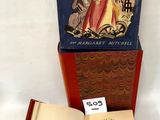 un livre ouvert posé sur une table à côté d'un livre ouvert