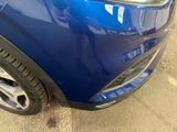 a close up of a blue car parked in a parking lot