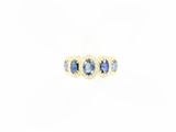 un gros plan d'une bague sertie de trois saphirs bleus