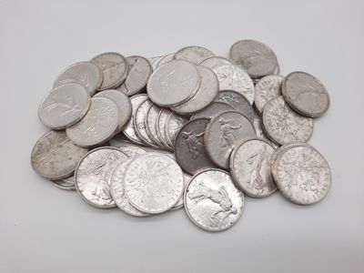 une pile de pièces d'argent empilées les unes sur les autres sur une surface blanche