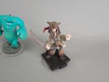 two figurines of a pirate and a monster on a table