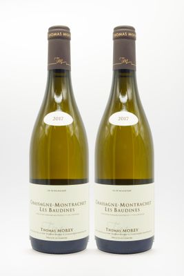 deux bouteilles de vin posées l'une à côté de l'autre sur une surface blanche