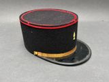 chapeau haut-de-forme noir avec un liseré rouge sur fond gris