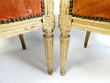 paire de chaises anciennes avec des assises rembourrées de cuir et des pieds en bois