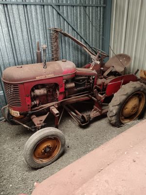 a red tractor parked in front of a building
