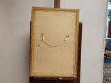 painting of a smiling face on an easel in a living room