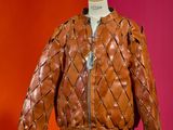 brown quilted leather jacket on mannequin stand against red wall