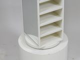 a small white tower with a mirror on top of it