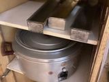 une casserole et une poêle posées sur une étagère dans un placard