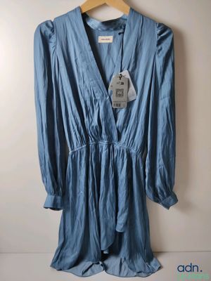 une photo d'une robe bleue suspendue à un cintre accroché au mur