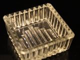 a clear glass ashtray on a black surface