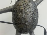 a metal sculpture of a spider on top of a ball