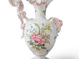 a white vase with pink flowers on it on a white background