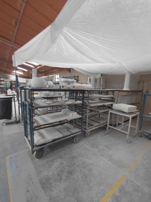a large room with a lot of tables and chairs under a white tarp