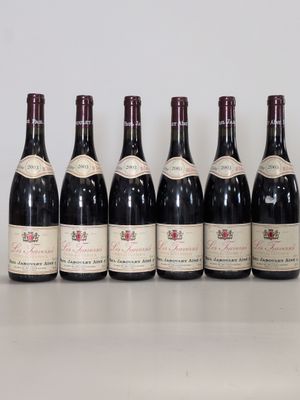 six bottles of wine are lined up on a table