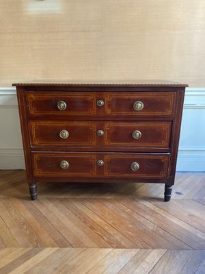 une commode en bois posée sur un parquet dans une pièce