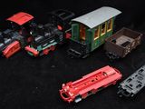 several toy trains are lined up on a black surface