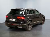 the rear end of a black volkswagen suv parked in a showroom
