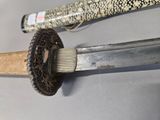 a close up of a sword with a wooden handle