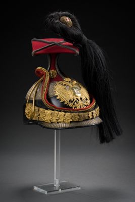 un casque rouge et doré sur lequel est posée une longue mèche de cheveux noirs