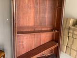 une armoire en bois avec une étagère et une chaise dans une pièce