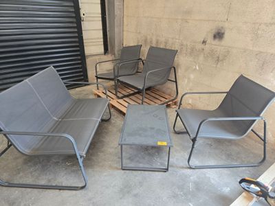quatre chaises et une table sur la terrasse en béton