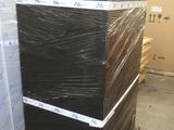une pile de boîtes noires posées sur une palette dans un entrepôt