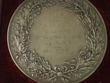 a silver medal in a wooden box on a table