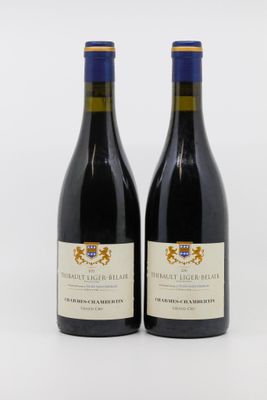 deux bouteilles de vin rouge posées l'une à côté de l'autre sur une surface blanche