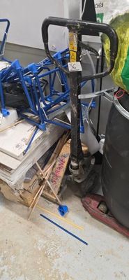 a pile of junk on the floor next to a trash can