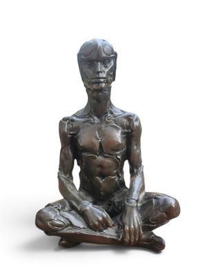 statue d'un homme assis en position du lotus sur un fond blanc
