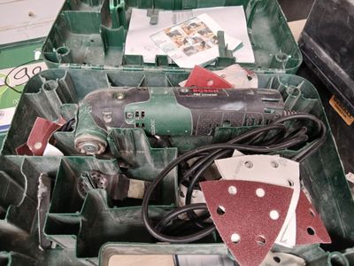 une boîte verte contenant des outils, posée sur une table